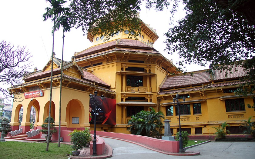 Yellow colonial-style facade and garden entrance of the Vietnam National Museum of History in Hanoi.