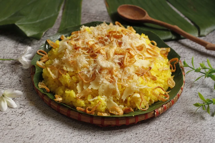 Hanoi breakfast of yellow sticky rice topped with shredded pork floss and fried shallots.