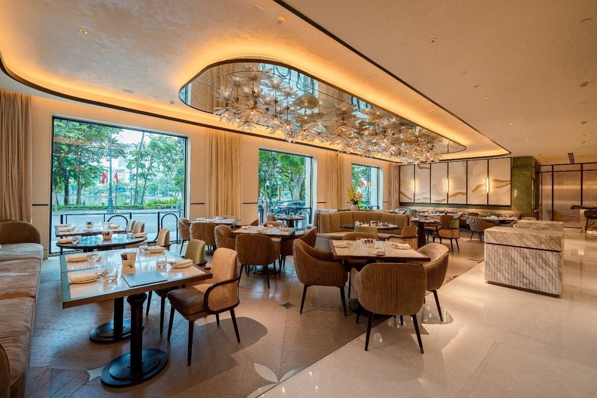 Dining room at The Theodore Hanoi with set tables and large windows.