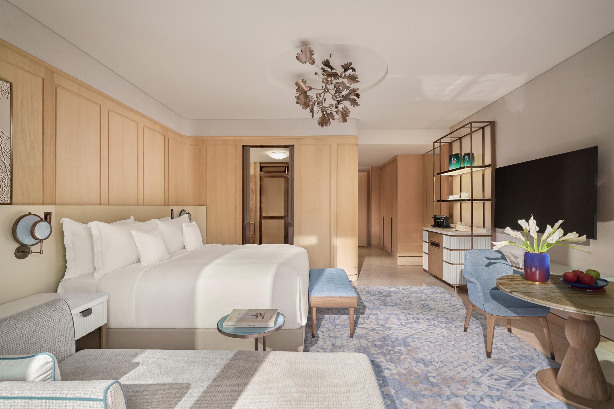 Signature Room with a king bed, pale wood panelling and a seating area at The Theodore Hanoi