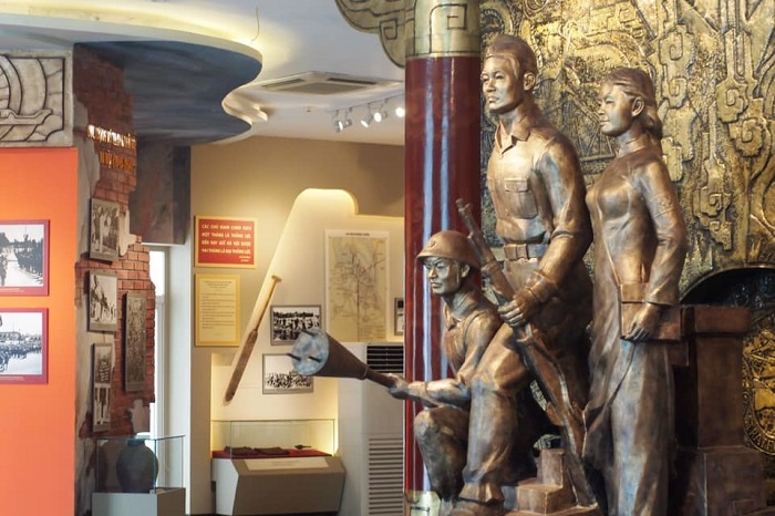 Historic wartime diorama with soldier figures and artifacts inside Hanoi's B-52 Victory Museum.