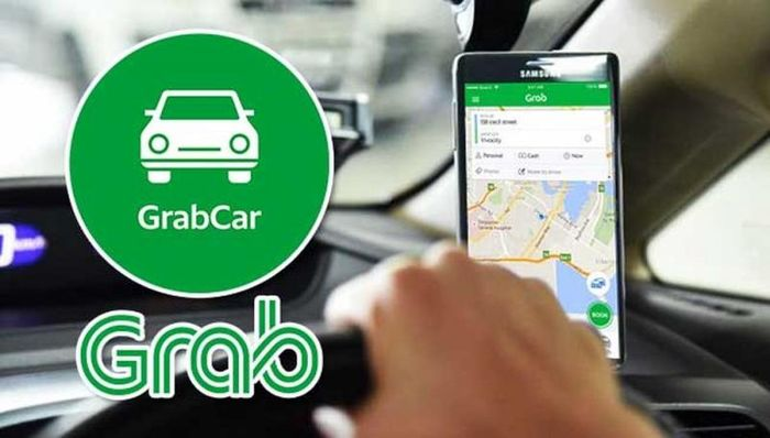 GrabCar sign and the ride-hailing app open on a phone inside a vehicle.