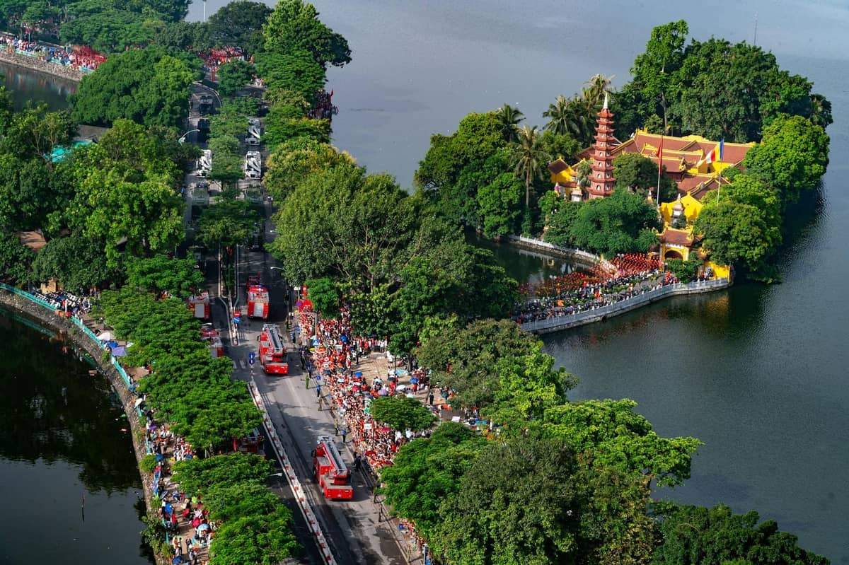Aerial view of Hoan Kiem Lake's wooded island and red footbridge in Hanoi.
