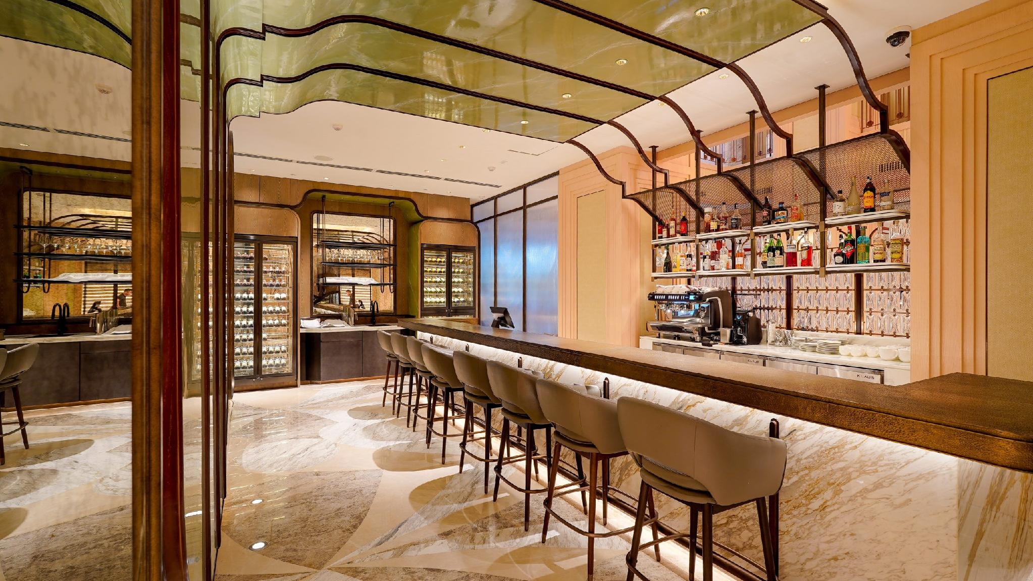 La Fournée bar counter with an espresso machine and backlit bottle shelves.
