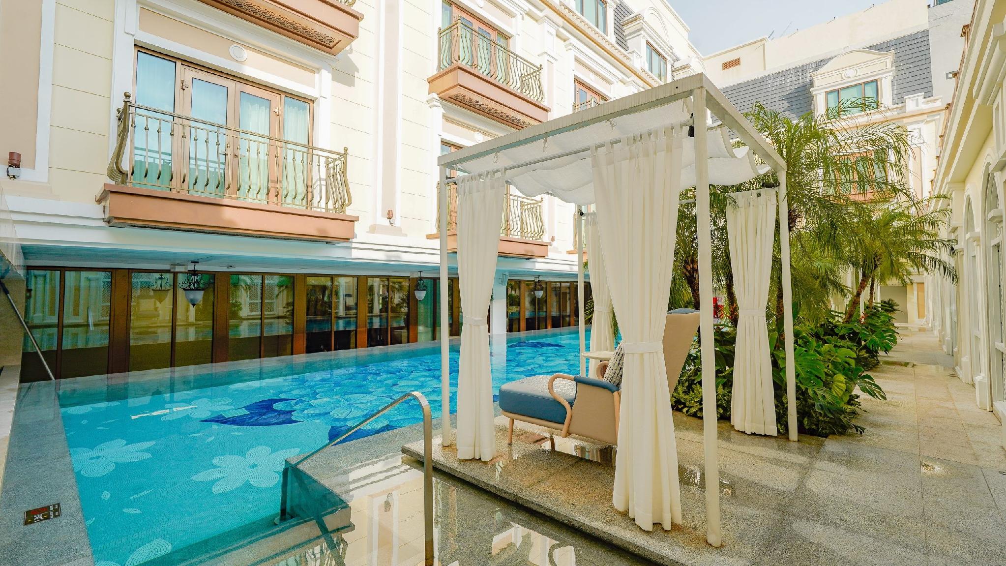 A cabana beside the outdoor pool at The Theodore Hanoi in morning light.