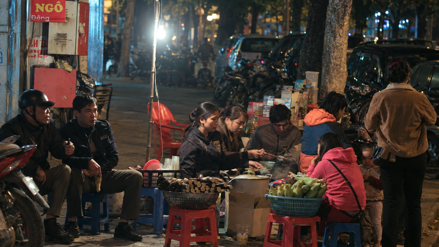Customers eat at low tables along an Old Quarter street at night.