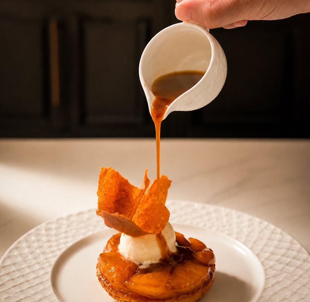 Chef drizzles sauce over a plated dessert at a Hanoi hotel restaurant.